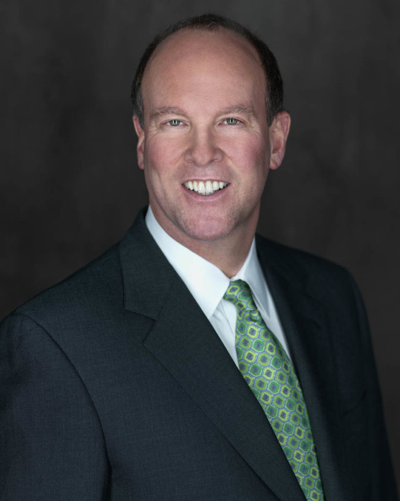 Annapolis Plastic Surgeon Dr. James Chappell in black suit with green tie