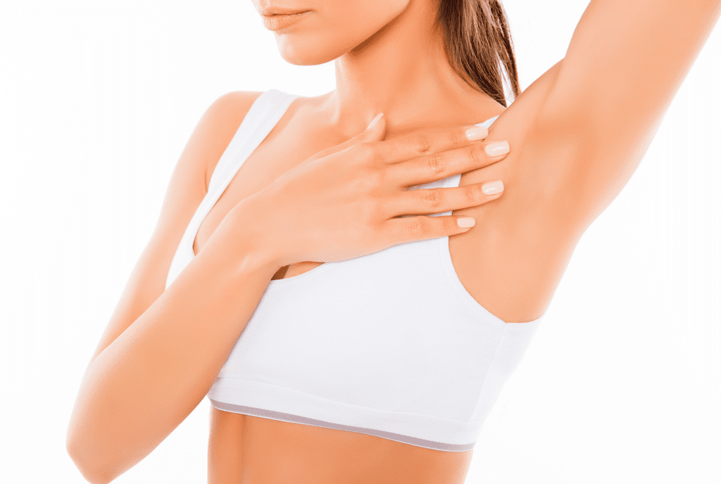 brown hair female in white sports bra touching chest showing left armpit
