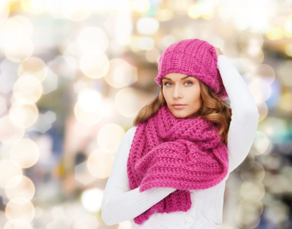brown hair female in pink hat and scarf with white top
