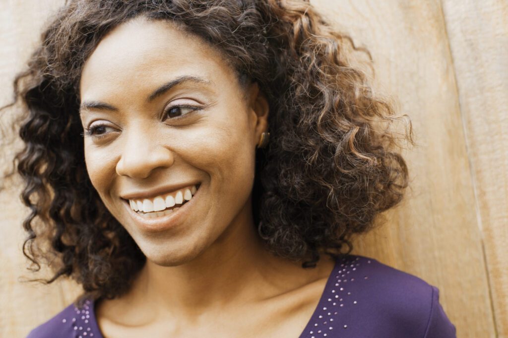 African american female with brown hair in a purple dress