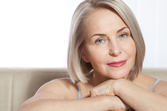 older blond hair woman resting her face on her hands