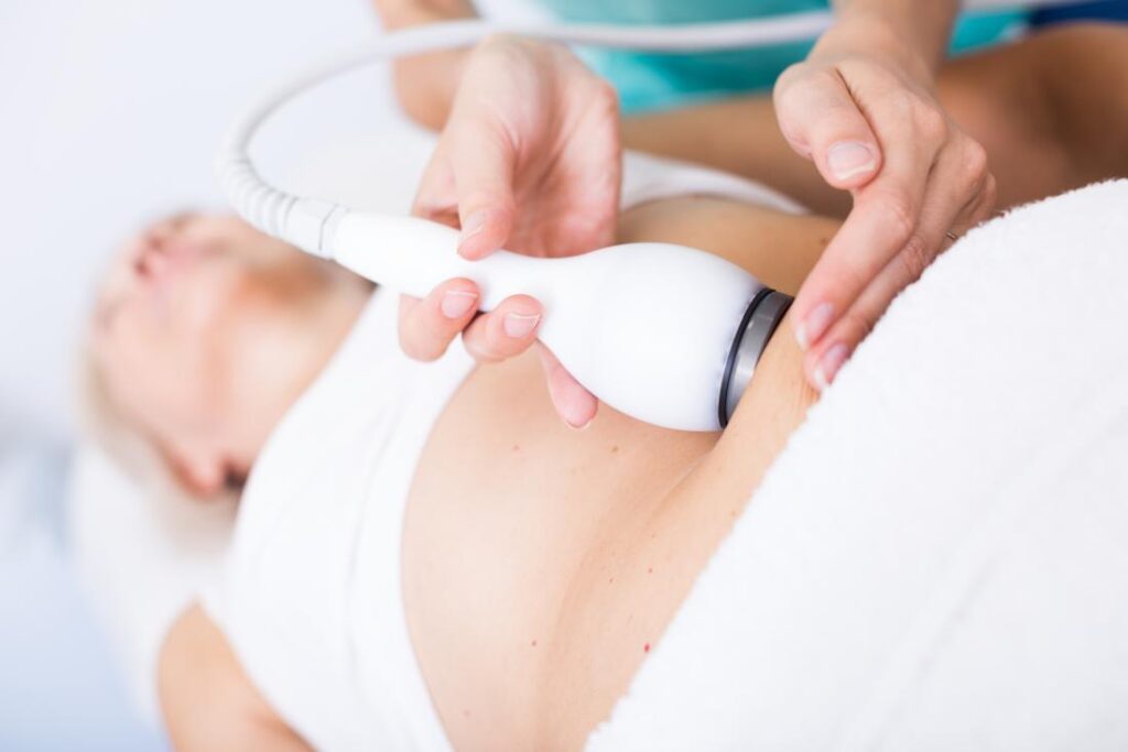 doctor performing coolsculpting on blonde female patient