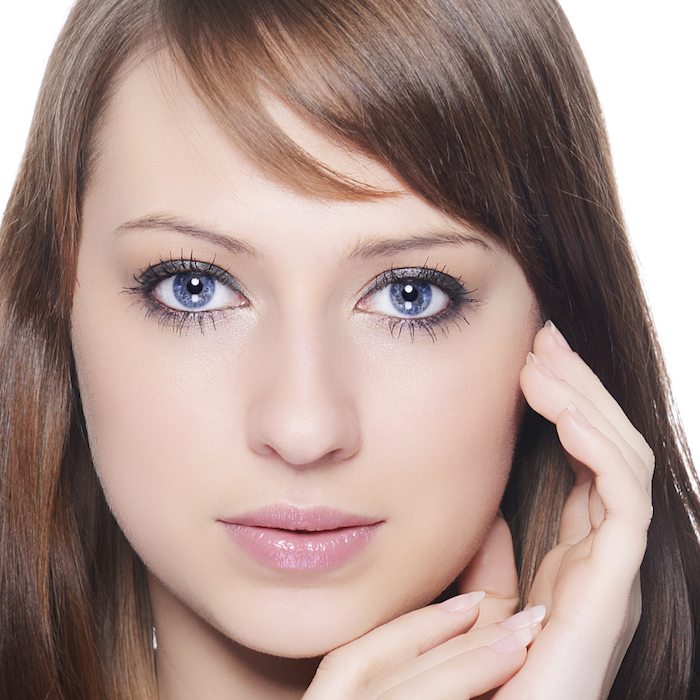 brown hair blue eyes female touching cheek