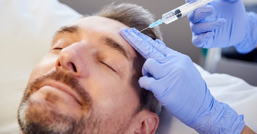older male getting injections to face from doctor